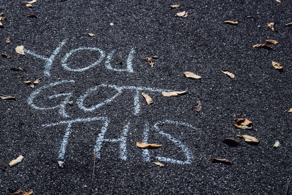 Chalk writing on the sidewalk that says, you got this. A message to fight imposter syndrome